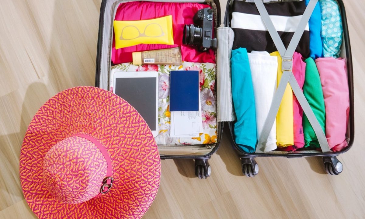 Open carry-on suitcase packed for a trip, seen from above