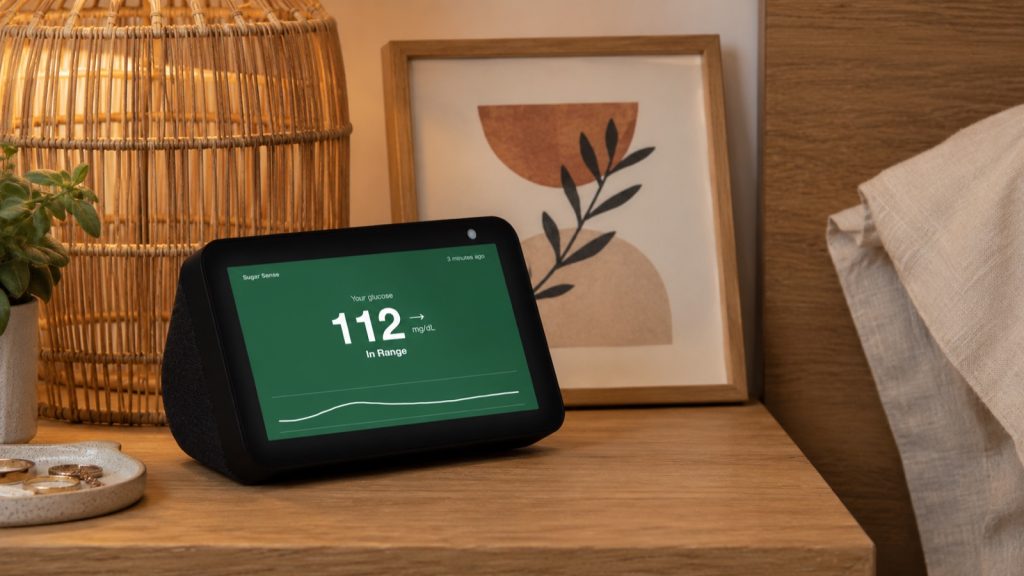 Sugar Sense glucose card on an Amazon Echo Show: 112 mg/dL, steady trend arrow, In Range, with a three hour graph on a green background